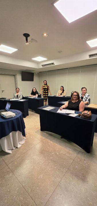 Sala de reunião com mesas dispostas em U e turma reduzida durante treinamento in company