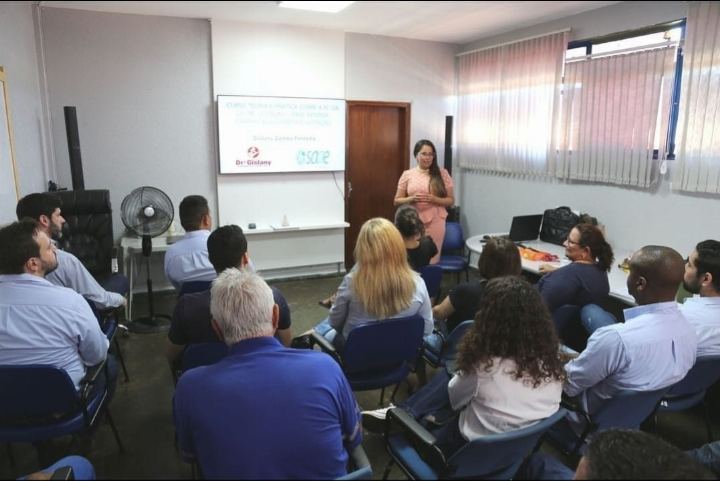 Participantes sentados acompanhando a apresentação da Dra Gislany