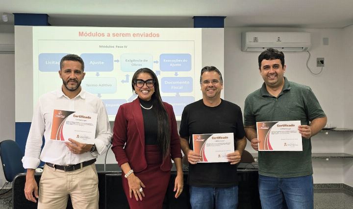 Quatro participantes com os certificados diante da projeção do curso