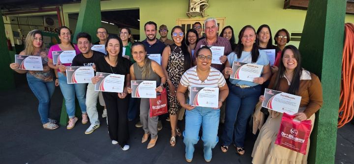 Turma reunida segurando os certificados ao fim do curso