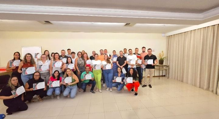 Turma numerosa com os certificados em salão amplo