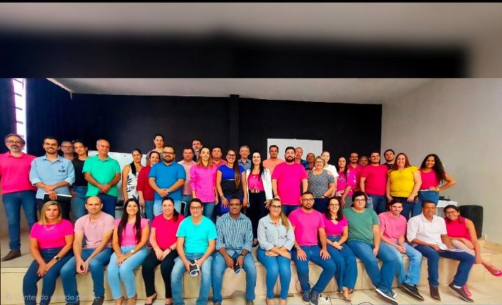 Turma numerosa reunida no palco do auditório ao fim da capacitação