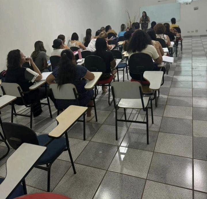 Turma do preparatório para concursos vista de lado, com alunos acompanhando a explicação da Dra Gislany à frente da sala