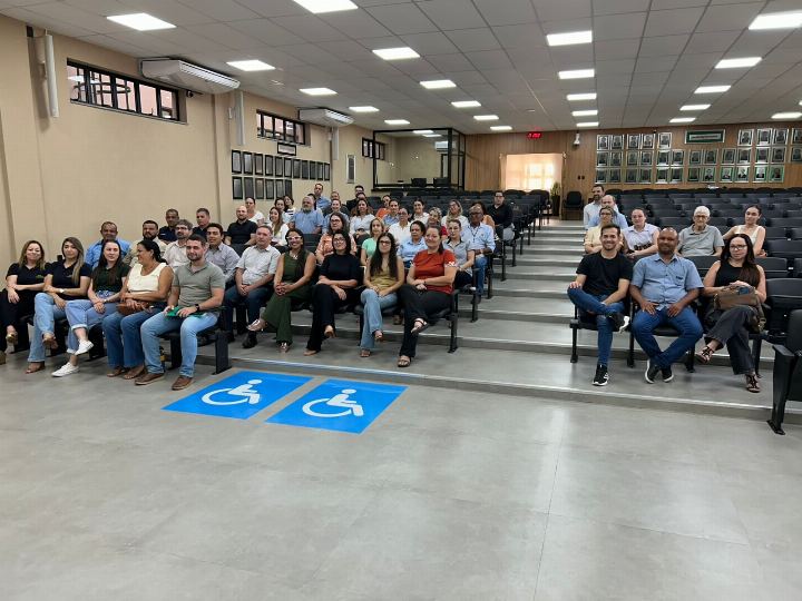 Auditório em arquibancada com dezenas de servidores sentados durante a capacitação