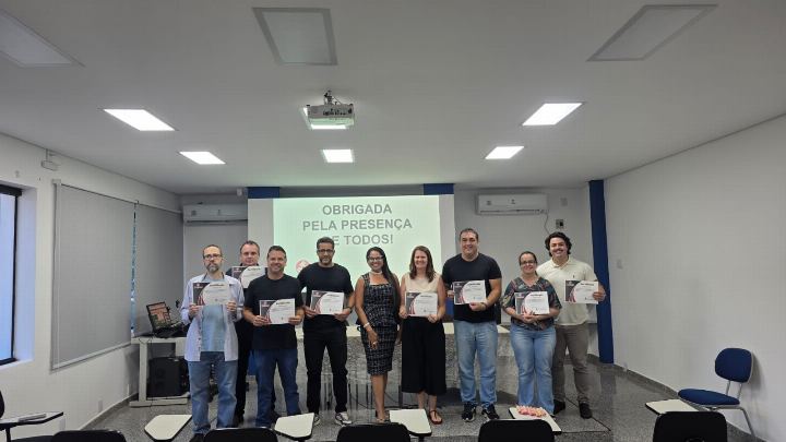 Participantes com os certificados em sala de treinamento