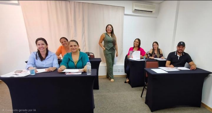 Dra Gislany conduzindo turma reduzida em sala de treinamento com mesas em U